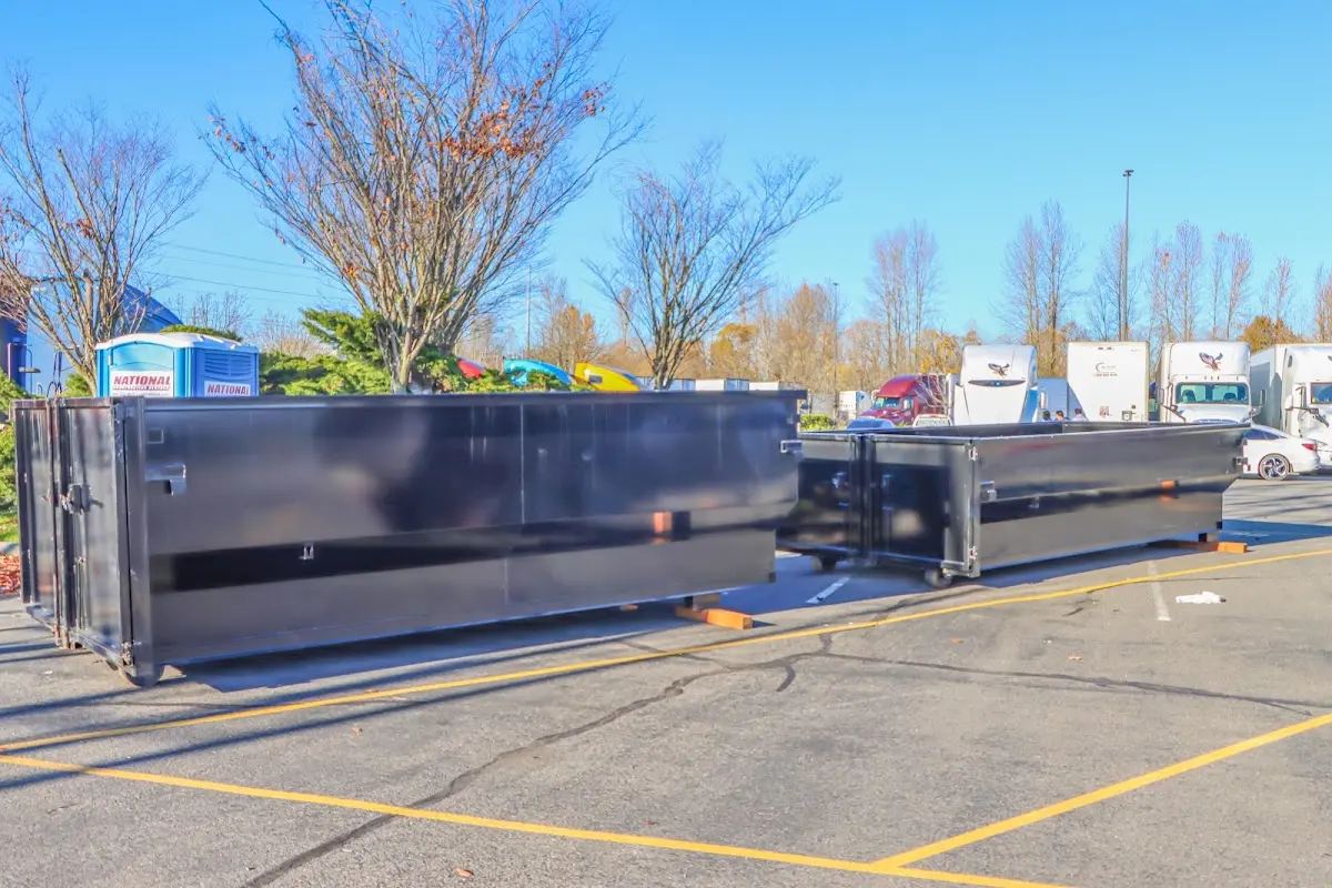 Professional dumpster rental service with roll-off container on residential driveway in University Place